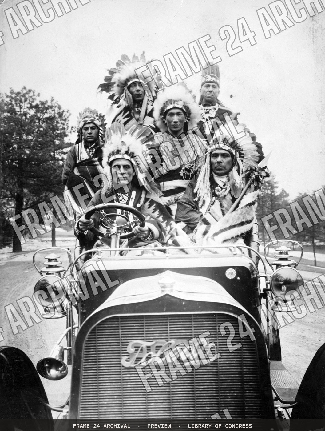 Indians in an automobile (1905), restored vintage black and white photograph