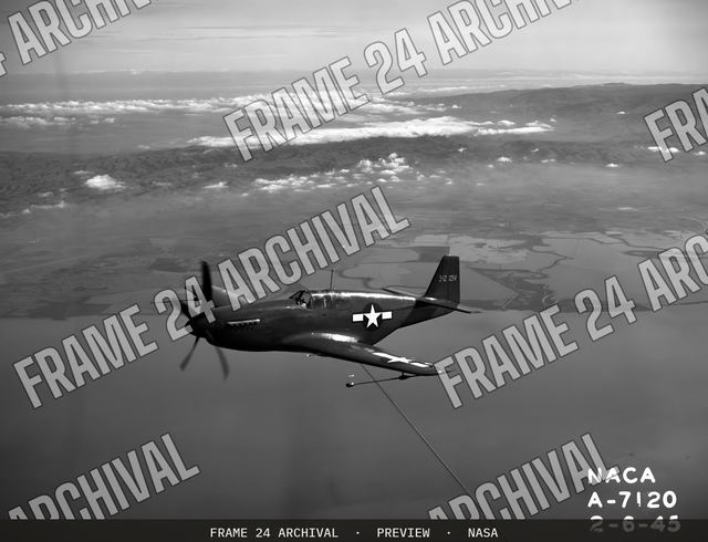 North American P-51B 'Mustang' fighter in flight over bay area, vintage black and white photograph